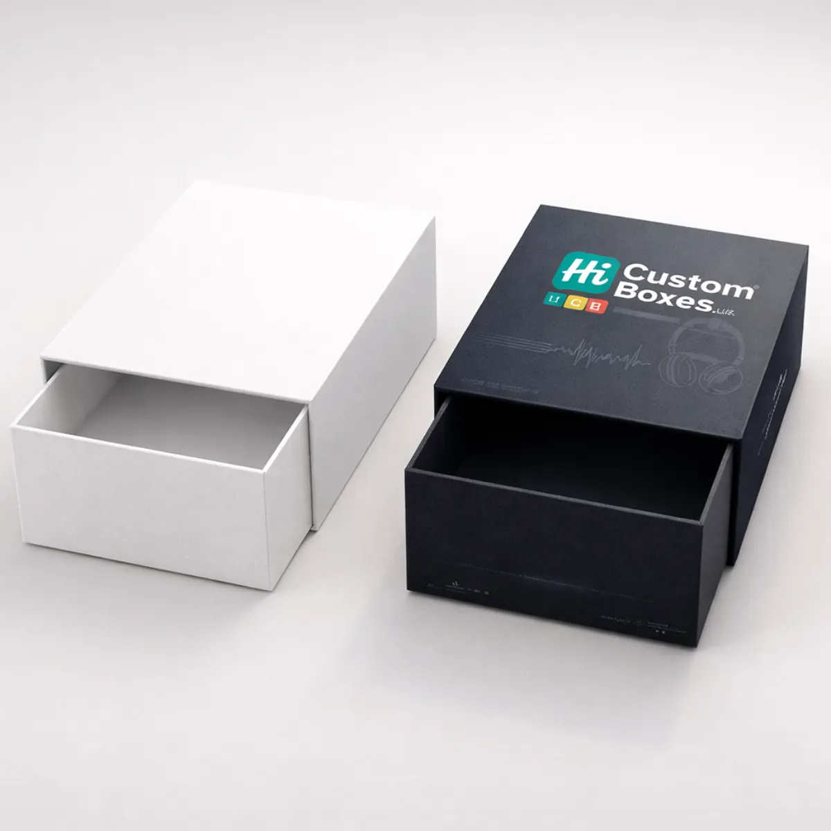 A white sliding drawer box next to a black premium drawer box printed with brand logos. class=